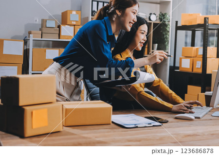 Asian SME business women use laptop computer checking customer order online shipping boxes at home. Starting Small business entrepreneur SME freelance. Online business, Work at home concept. 123686878