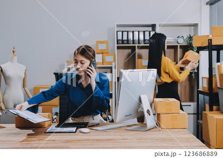 Asian SME business women use laptop computer checking customer order online shipping boxes at home. Starting Small business entrepreneur SME freelance. Online business, Work at home concept. 123686889