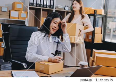 Asian SME business women use laptop computer checking customer order online shipping boxes at home. Starting Small business entrepreneur SME freelance. Online business, Work at home concept. 123686919