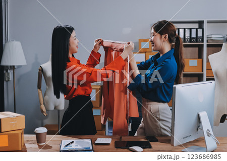 Fashion blogger concept, Young Asian women selling clothes on video streaming.Startup small business SME, using smartphone or tablet taking receive and checking in office Fashion blogger concept, Young Asian women selling clothes on video streaming.Startup small business SME, using smartphone or tablet taking receive and checking in office 123686985