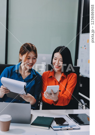 Entrepreneur Asian businessman and businesswoman discussing new business project in tablet in modern Meeting In Modern Office, Asian business casual concept. 123686988