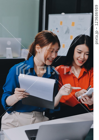 Entrepreneur Asian businessman and businesswoman discussing new business project in tablet in modern Meeting In Modern Office, Asian business casual concept. 123686989