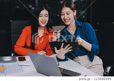 Entrepreneur Asian businessman and businesswoman discussing new business project in tablet in modern Meeting In Modern Office, Asian business casual concept. 123686999