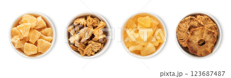 Bowl plates with sweet dried and soft pineapple pieces and circles isolated on white background. 123687487