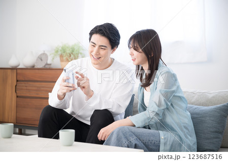 スマホを見る夫婦 画面に指を差す スマホを見る夫婦 画面に指を差す 123687516