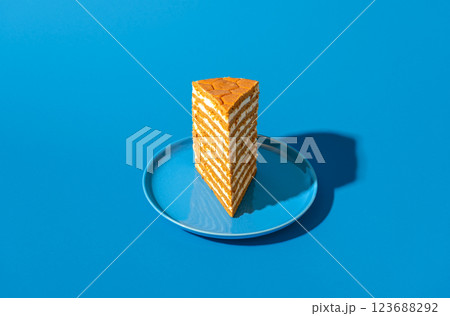Honey layered cake slice, russian recipe, isolated on a blue background 123688292