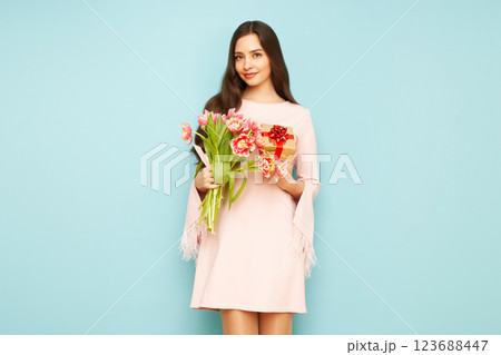 Woman hold bouquet of flowers and golden gift box 123688447