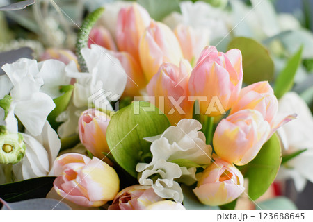 Beautiful holiday card. Mother Day greeting card. Delicate bouquet of white ranunculus and pastel tulips with soft green leaves, creating a romantic and elegant floral scene 123688645