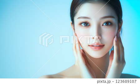 美肌の若くて綺麗なアジア人女性モデルの美容ポートレート。両手を頬に当てるポーズをしている。 123689107