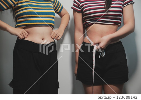 Women body fat belly. Obese woman hand holding excessive belly fat. diet lifestyle concept to reduce belly and shape up healthy stomach muscle. 123689142