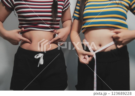 Women body fat belly. Obese woman hand holding excessive belly fat. diet lifestyle concept to reduce belly and shape up healthy stomach muscle. Women body fat belly. Obese woman hand holding excessive belly fat. diet lifestyle concept to reduce belly and shape up healthy stomach muscle. 123689228
