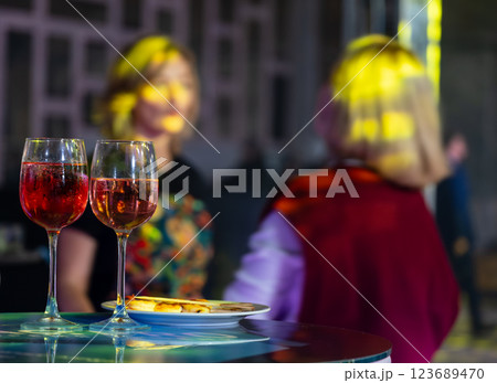 Glasses of wine at a lively social event 123689470