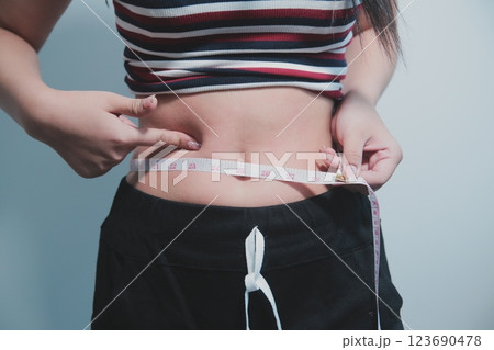 Women body fat belly. Obese woman hand holding excessive belly fat. diet lifestyle concept to reduce belly and shape up healthy stomach muscle. Women body fat belly. Obese woman hand holding excessive belly fat. diet lifestyle concept to reduce belly and shape up healthy stomach muscle. 123690478