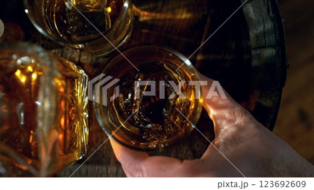 Detail of man hand holding whiskey drink. Freeze motion of drink preparation. Detail of man hand holding whiskey drink. Freeze motion of drink preparation. 123692609
