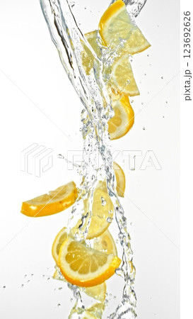 Fresh lemon slices falling in water splashes, isolated on white background. Fresh lemon slices falling in water splashes, isolated on white background. 123692626