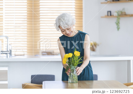 自宅に花を飾るシニア女性 自宅に花を飾るシニア女性 123692725