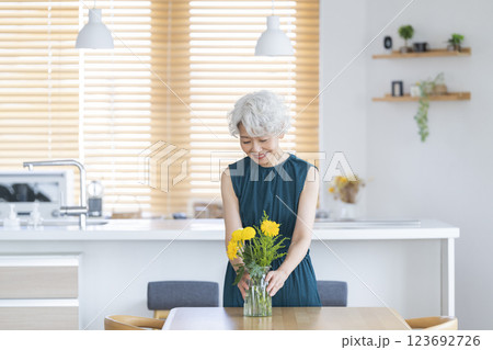 自宅に花を飾るシニア女性 自宅に花を飾るシニア女性 123692726