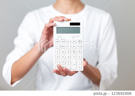 白い電卓を持つミドル女性 123692806