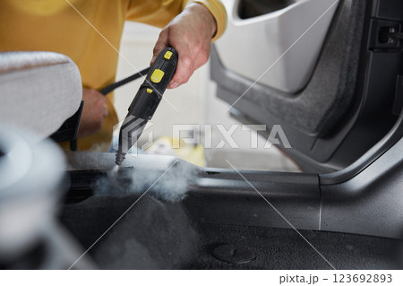 Service worker using cleaning properties of steam for cleansing car interior 123692893