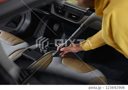 Car service worker cleaning front seats from dust and dirt using vacuum cleaner Car service worker cleaning front seats from dust and dirt using vacuum cleaner 123692906