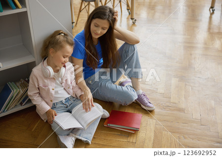 Happy mother and daughter spending time together in library or bookstore Happy mother and daughter spending time together in library or bookstore 123692952