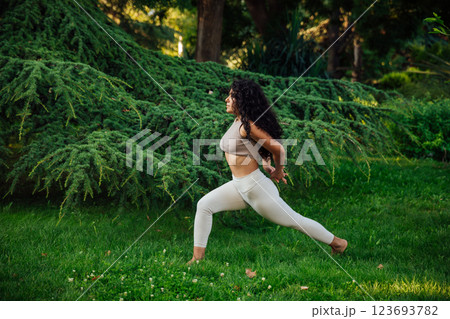 Woman doing yoga fitness asana in the park on the grass Woman doing yoga fitness asana in the park on the grass 123693782