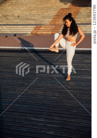 woman doing gymnastics yoga asana outdoors 123693790
