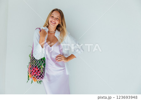 woman holding a bag with fresh vegetables and fruits in her hands 123693948