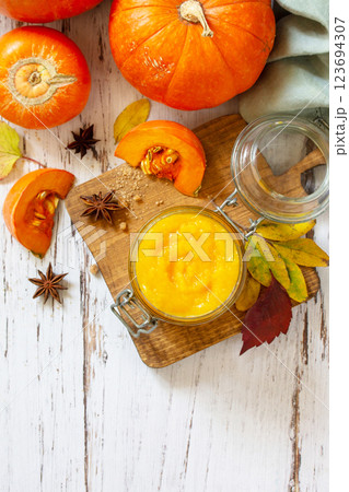 Pumpkin Puree with spices and Pumpkin on a wooden table. Top view flat lay background. Copy space. 123694307