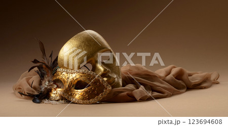 Golden Venetian carnival masks on a beige background. 123694608