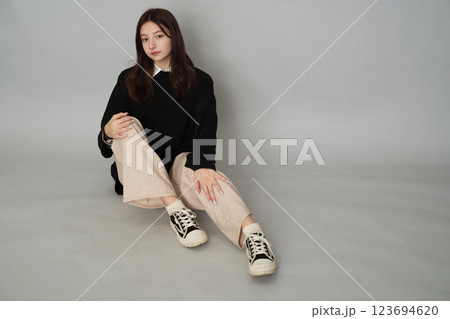 A 13-year-old girl, looking wistful in a chic sweater, embodies the quiet introspection and sensitivity common in teen experiences. 123694620
