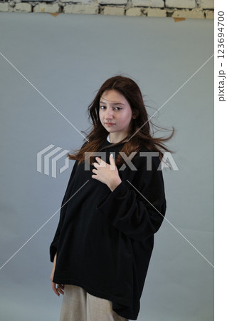 Female with hair billowing, captures the essence of a light-hearted day. Represents the ease of youth and natural elegance. 123694700