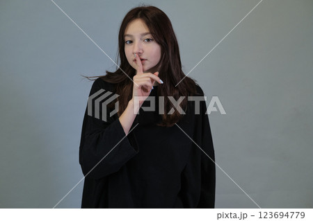 Muted expression with a finger to lips, signaling secrecy. Reflects the intrigue in silence and personal privacy. Muted expression with a finger to lips, signaling secrecy. Reflects the intrigue in silence and personal privacy. 123694779