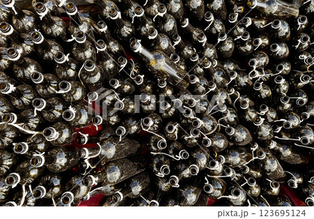 Empty dark wine bottles in close-up at an exhibition and sale of high-quality alcohol. A large number of bottles in the form of silhouettes and shapes in the design with garters and bows 123695124