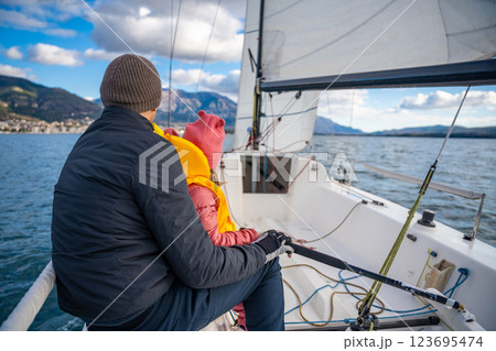Father instructing daughter on sailing a yacht during training in the Kotor Bay, Montenegro, highlighting family bonding, adventure, and nautical sport. 123695474
