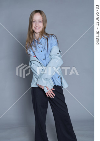 Girl with a cheeky smile, clad in modern attire, embodies lighthearted fashion. Ideal for youth lifestyle brands. Girl with a cheeky smile, clad in modern attire, embodies lighthearted fashion. Ideal for youth lifestyle brands. 123695783