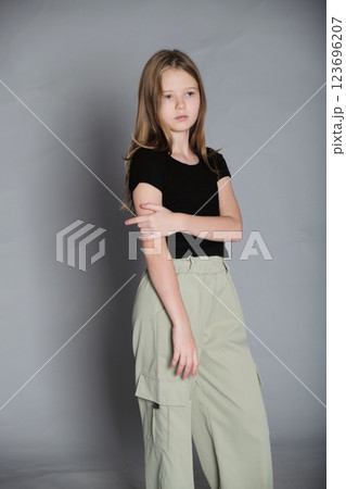 Confident child poses, her arms crossed, eyes thoughtful. Capturing the essence of growing independence in youth. 123696207