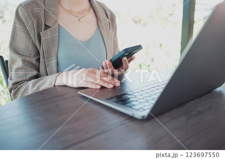 Close up female hands using smartphone shopping online, Freelancer remote working from coffee shop. 123697550