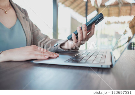 Close up female hands using smartphone shopping online, Freelancer remote working from coffee shop. 123697551