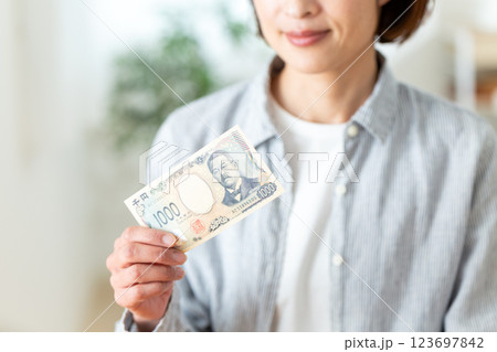 千円札を持つミドル女性 123697842