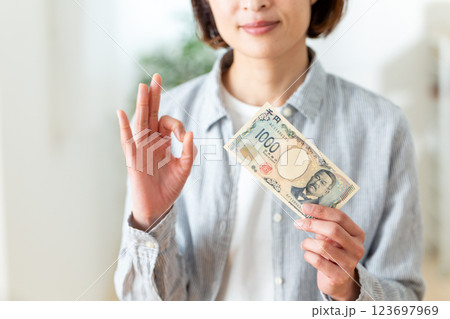 千円札を持って丸サインをするミドル女性 千円札を持って丸サインをするミドル女性 123697969