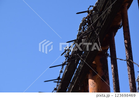 錆びた鉄柵と朽ちた木材の有刺鉄線 123698469