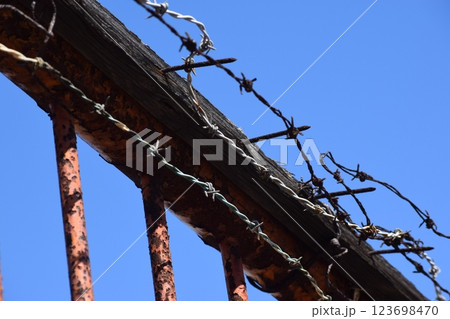 錆びた鉄柵と朽ちた木材の有刺鉄線 錆びた鉄柵と朽ちた木材の有刺鉄線 123698470