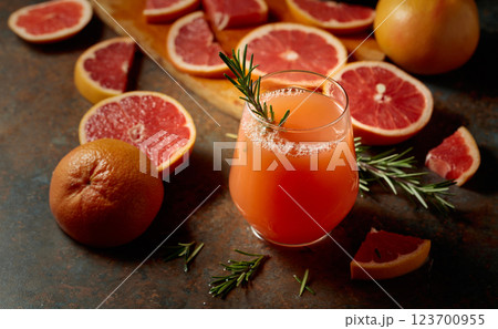 A glass of grapefruit juice garnished with a rosemary sprig. A glass of grapefruit juice garnished with a rosemary sprig. 123700955