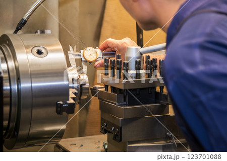Close up scene the machine operator measuring dimension of turning parts by dial Vernier caliper. Close up scene the machine operator measuring dimension of turning parts by dial Vernier caliper. 123701088