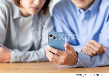 家でスマホを見るミドル夫婦 家でスマホを見るミドル夫婦 123701108