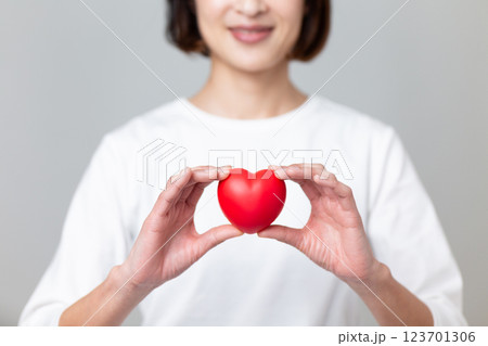ハートマークを持つ笑顔のミドル女性 123701306