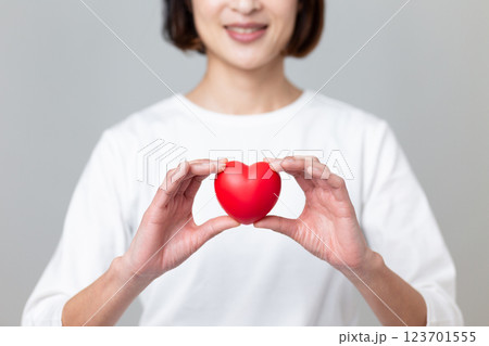 ハートマークを持つ笑顔のミドル女性 ハートマークを持つ笑顔のミドル女性 123701555