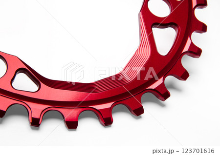Close up of a red oval bicycle chainring against white isolated background. Professional bicycle part. Close up of a red oval bicycle chainring against white isolated background. Professional bicycle part. 123701616