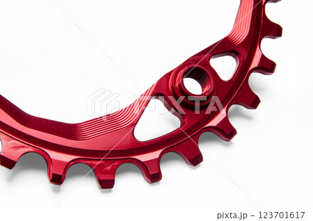 Close up of a red oval bicycle chainring against white isolated background. Professional bicycle part. Close up of a red oval bicycle chainring against white isolated background. Professional bicycle part. 123701617